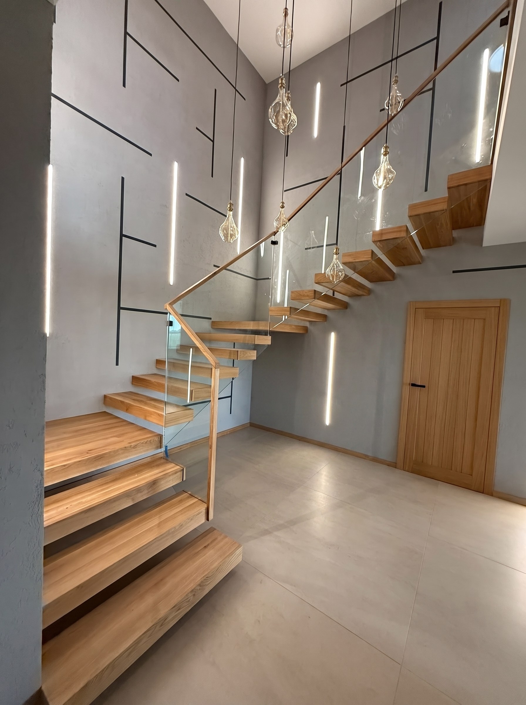 Schody wspornikowe z dębu ze szklaną balustradą i żarówkami Edisona